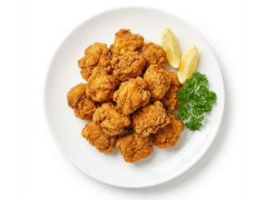 Plato de pollo frito karaage japonés con rodajas de limón y perejil fresco